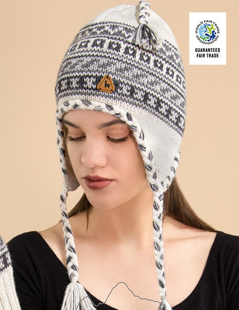 woman wearing alpaca chullo hat with earflaps soft warm with fleece lining unisex, geometric with natural base, black, grey design 